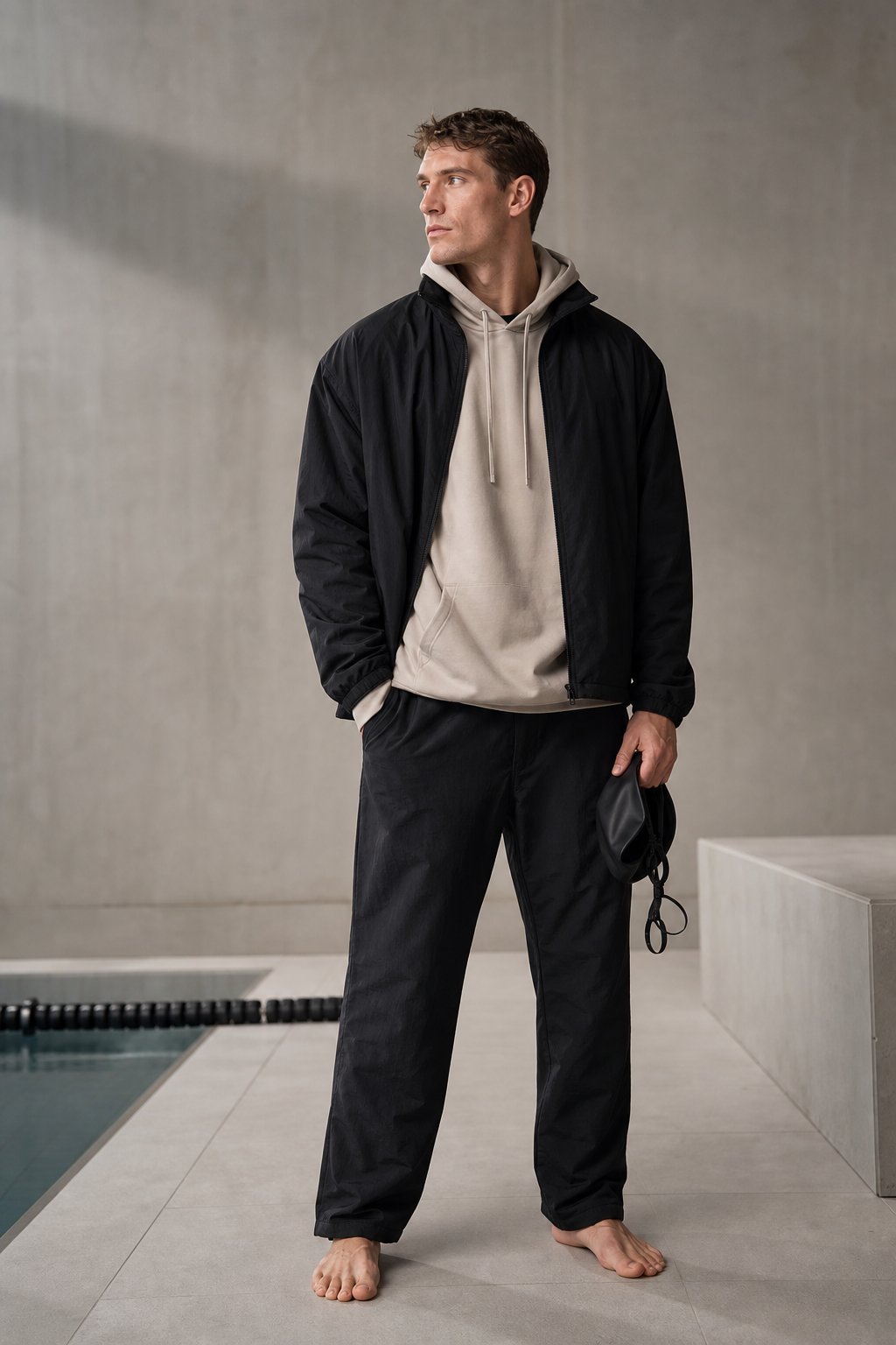Editorial portrait of an anonymous athlete in minimalist black and greige athleticwear.